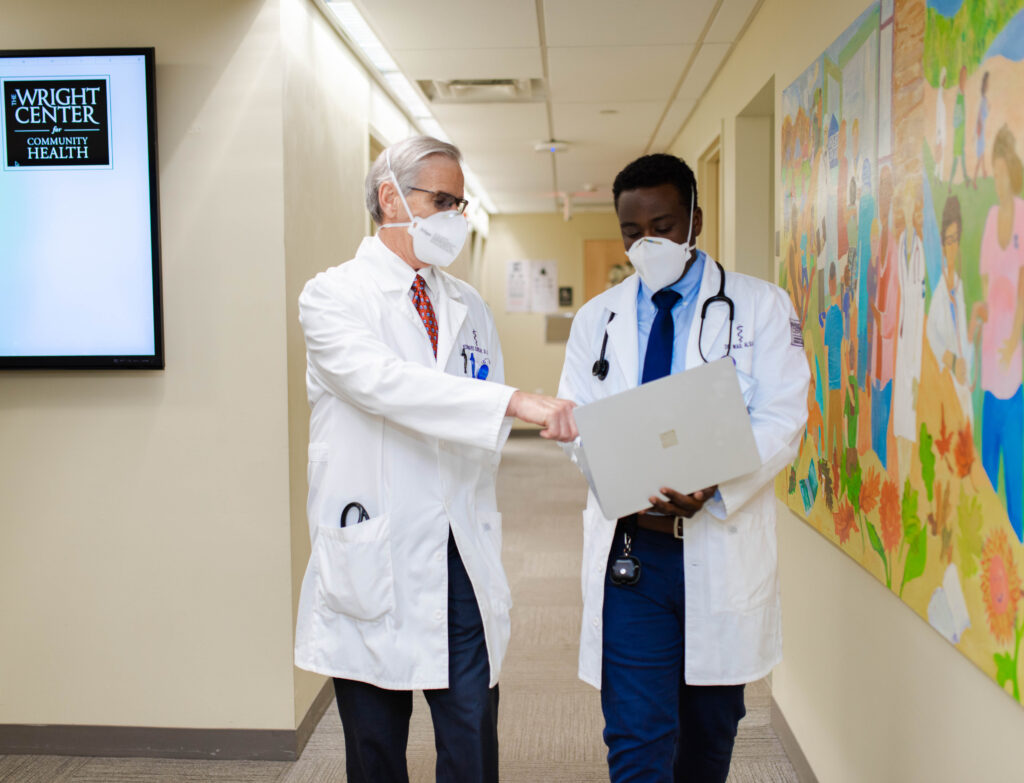 Doctor walking down hallway with resident