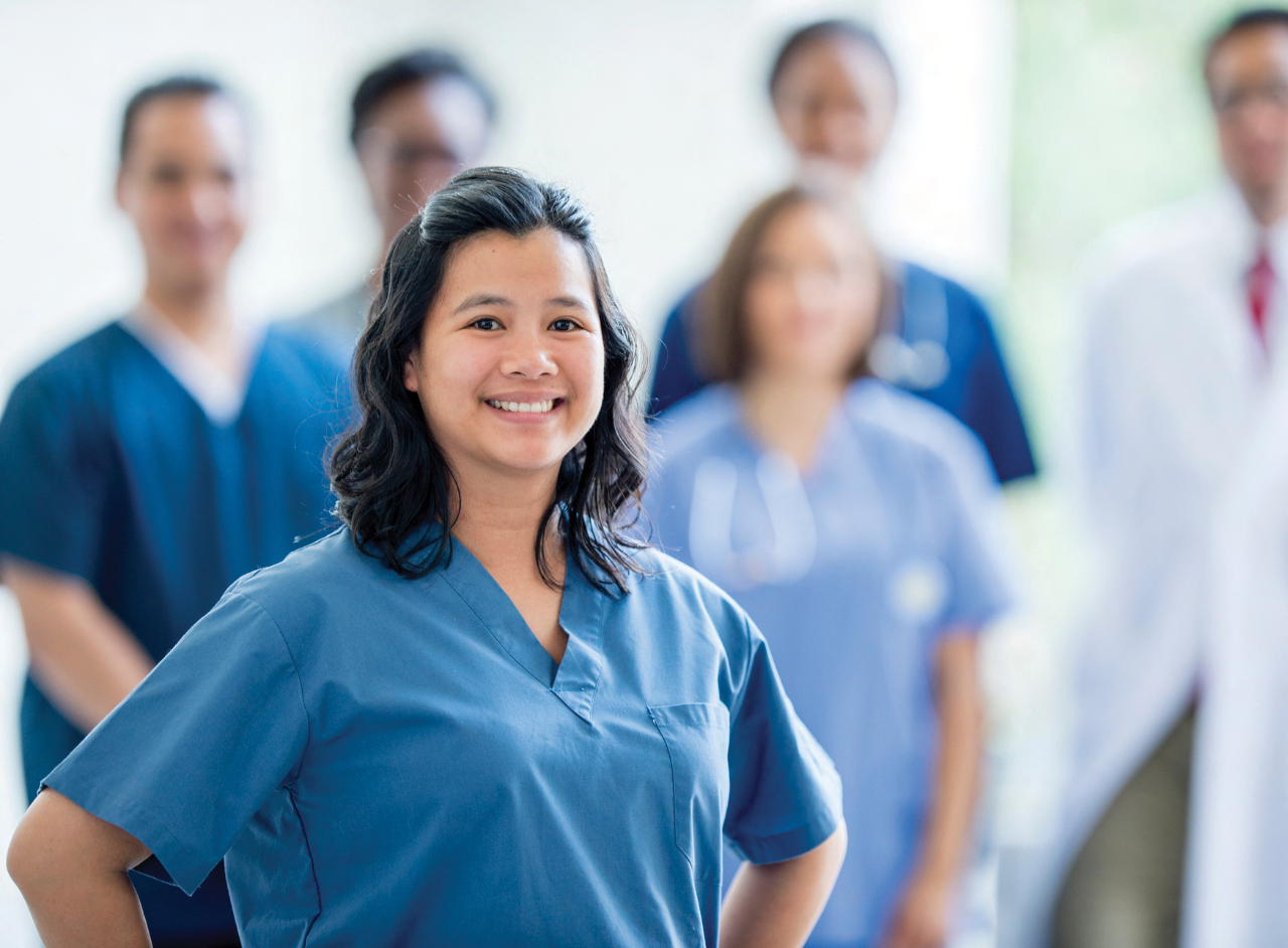 Female nurse smiling in blue scrubs 